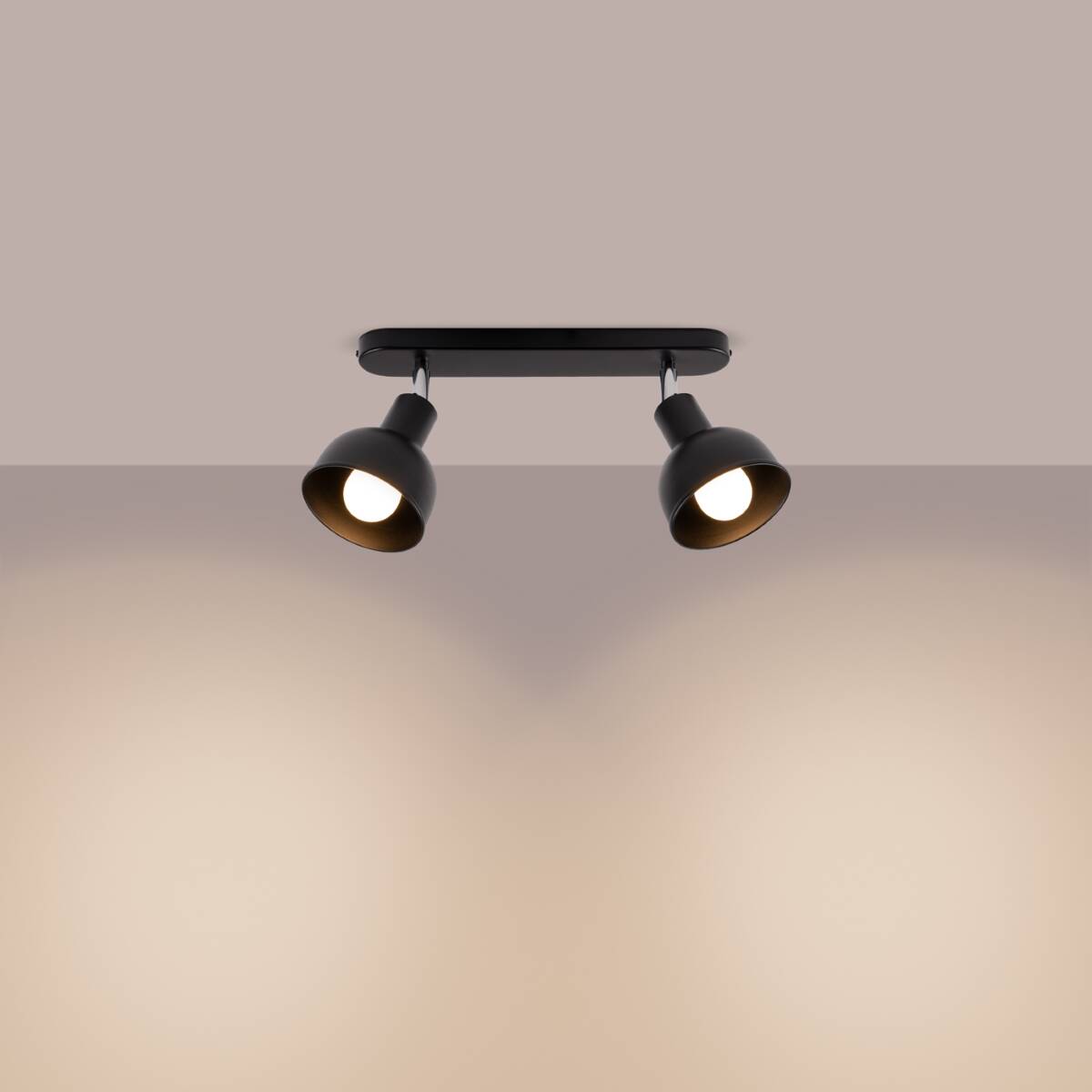 Czarna lampa sufitowa Elba z dwoma reflektorami typu spot, montowana na płaskiej podstawie. Reflektory ustawione równolegle, skierowane w dół, z widocznymi żarówkami E27. Tło w jasnym odcieniu, podkreślające design lampy.
