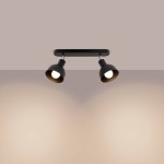 Czarna lampa sufitowa Elba z dwoma reflektorami typu spot, montowana na płaskiej podstawie. Reflektory ustawione równolegle, skierowane w dół, z widocznymi żarówkami E27. Tło w jasnym odcieniu, podkreślające design lampy.