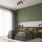 Lampa sufitowa Elba w kolorze czarnym z dwoma reflektorami E27, zamontowana na suficie w sypialni. Oświetlenie skierowane na łóżko z szaro-zieloną pościelą, w otoczeniu zielonych szafek i zasłon w odcieniu szarości.