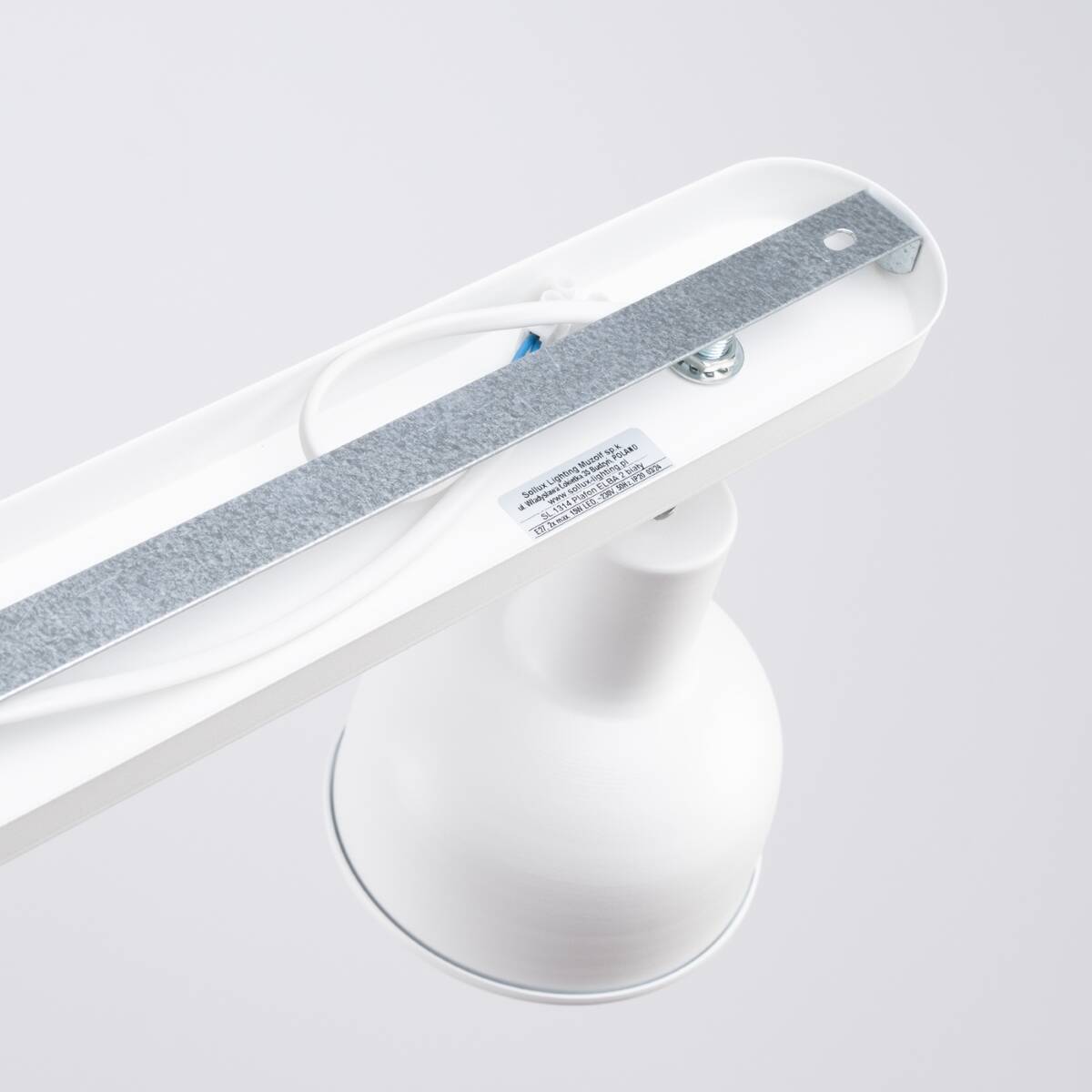 Lampa sufitowa Elba w kolorze białym, z podwójnym punktem świetlnym, z metalowym mocowaniem. Widoczny detal lampy z uchwytem montażowym i przewodami elektrycznymi. Prosty design, zbliżenie na górną część lampy.