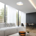 Lampa sufitowa LED Astro ML6355 o mocy 40W w białej obudowie, zamontowana na suficie w nowoczesnym wnętrzu. W tle widoczne okna z białymi zasłonami, kanapa z poduszkami oraz stół z krzesłami.