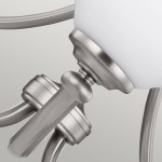 Lampa wisząca Vintner 3xE27 w niklu satynowym. Detal przedstawia element mocujący z metalowym wykończeniem oraz okrągłą, białą szklaną klosz. Kształt elegancki, z delikatnymi liniami, idealny do nowoczesnych wnętrz.