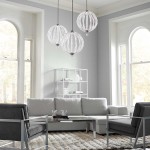 Lampa wisząca Oberlin M z niklowanym satynowym wykończeniem, z dwoma źródłami LED 8W. Zawieszona w salonie, w towarzystwie trzech okrągłych kloszy z przezroczystymi elementami, na tle jasnoszarych ścian i nowoczesnych mebli.