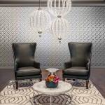 Lampa wisząca Oberlin M z dwoma kloszami LED o mocy 8W, wykonana z niklu satynowego, zawieszona nad stolikiem kawowym w eleganckim wnętrzu z czarnymi fotelami i dekoracyjnym dywanem. Tło w jasnych odcieniach z geometrycznym wzorem.
