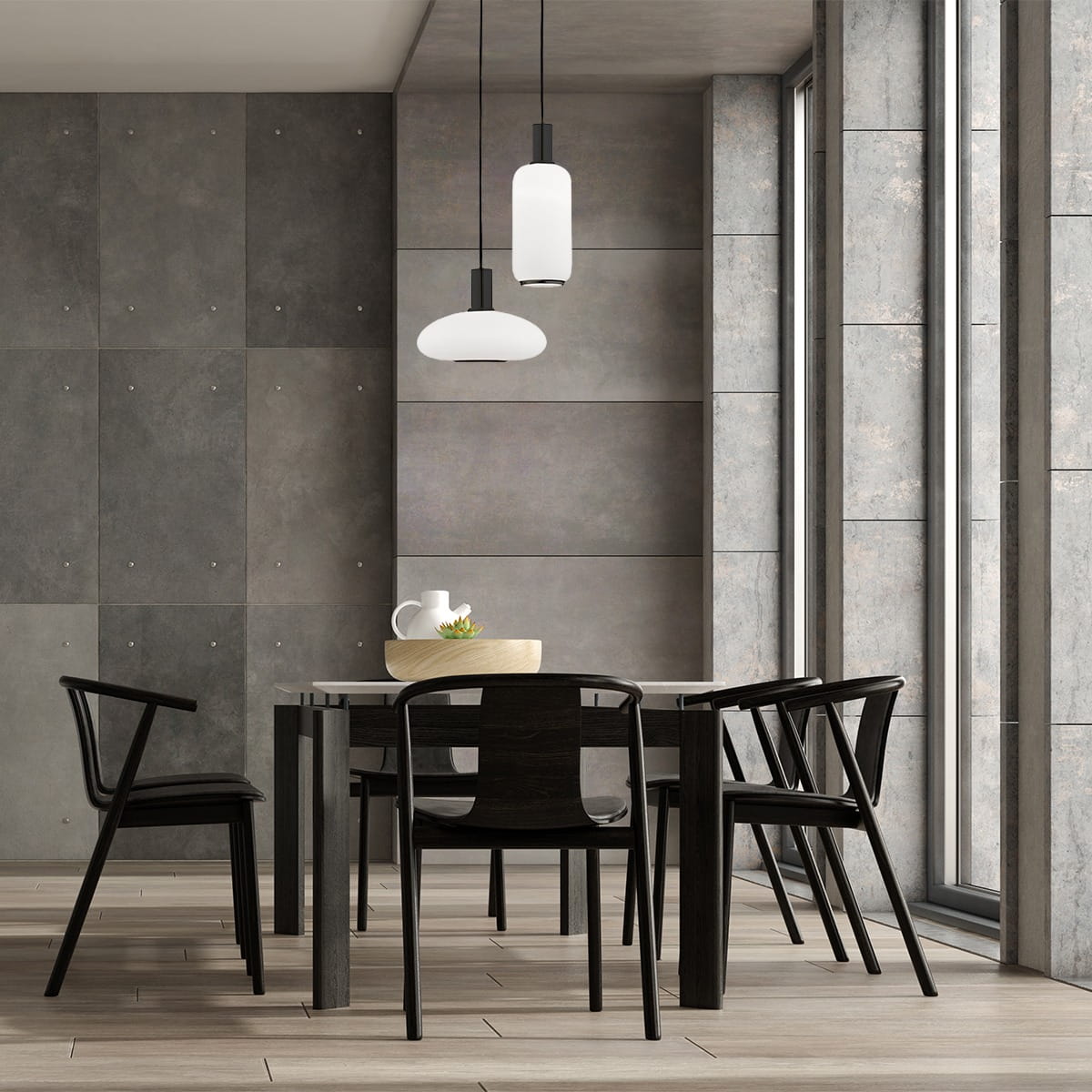 Lampa wisząca Sagunto Plus 2xE27 w kolorze czarnym i białym, zawieszona nad stołem, z okrągłym i cylindrycznym kloszem. W tle widoczne szare ściany i duże okna, wnętrze nowoczesne z drewnianą podłogą i czarnymi krzesłami.