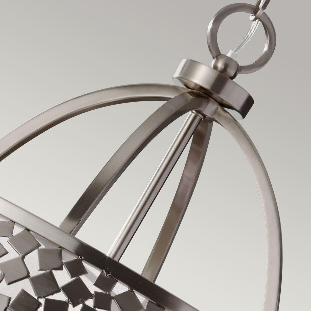 Lampa wisząca Zara 4xE14 w satynowym niklu, z metalową konstrukcją. Górna część w formie elipsy z dekoracyjnymi elementami, zawieszona na przezroczystym kablu. Widać okrągły uchwyt mocujący. Tło w odcieniach szarości.