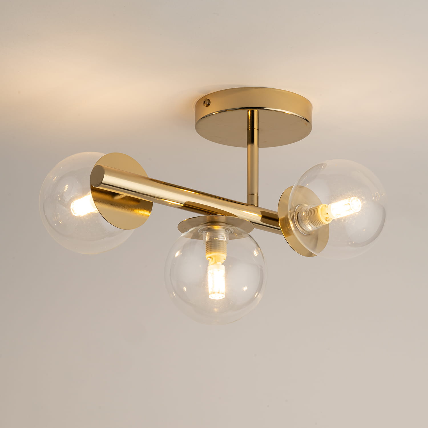 Lampa sufitowa Avola 3xG9 w kolorze złotym z przezroczystymi kloszami. Posiada trzy okrągłe, szklane klosze osadzone na metalowej, złotej konstrukcji, montowana do sufitu, w stylu nowoczesnym.