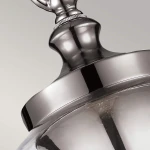 Lampa wisząca Tabby z satynowanego niklu, z okrągłym kloszem i metalowym wykończeniem. Widok z góry, ukazujący detale mocowania. Przezroczysty klosz, który podkreśla źródło światła.