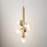 Lampa wisząca Perla Lux z pięcioma kloszami G9, w kolorze złotym i transparentnym. Klosze w formie kul są umieszczone na prostym, złotym stelażu. Lampa zawieszona na cienkim przewodzie, prezentuje nowoczesny design. Tło jasne, minimalistyczne.