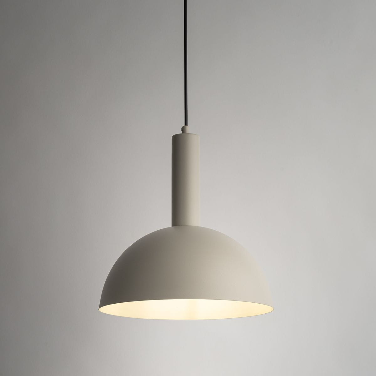 Lampa wisząca Vitrum Kopuła D30 w kolorze szaro-beżowym, z metalowym kloszem w kształcie półkuli. Montowana na czarnym przewodzie, z oprawką E27. Widoczny detal podświetlenia w dolnej części klosza.