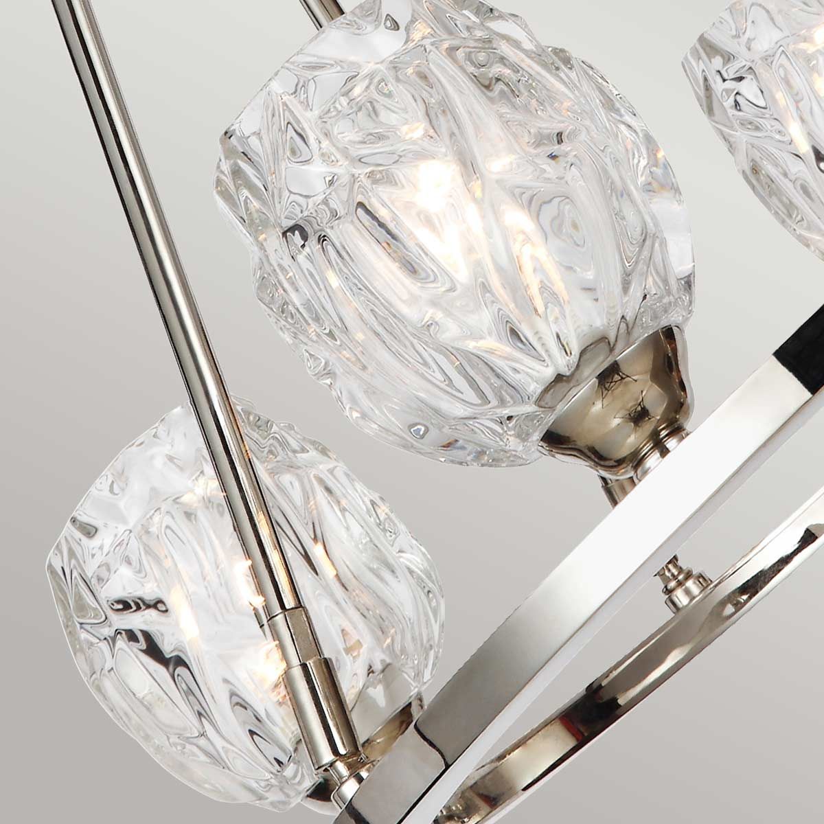 Lampa wisząca Rubin z czterema kloszami G9 wykonana z przezroczystego szkła w kształcie diamentu, zawieszona na metalowej konstrukcji w satynowym niklu. Klosze emitują ciepłe światło, tworząc elegancką atmosferę.