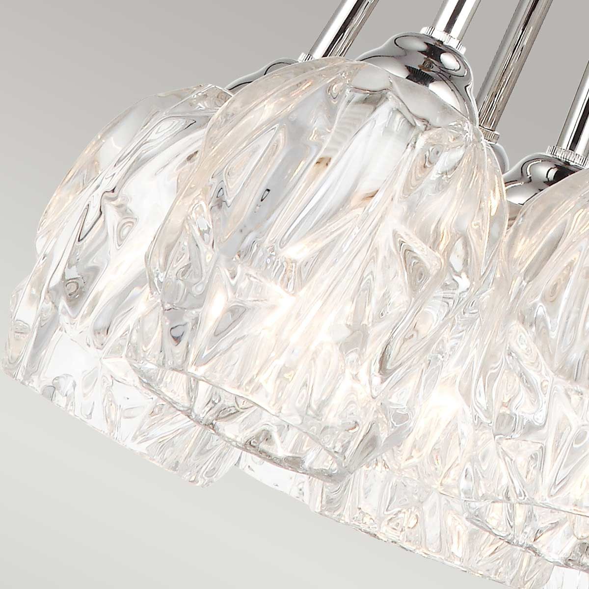 Lampa wisząca Rubin z siedmioma kloszami G9, wykonana z przezroczystego szkła z wzorem w formie fal. Uchwyt w kolorze satynowego niklu, z eleganckim wykończeniem. Widok z góry, pokazujący detale kloszy.
