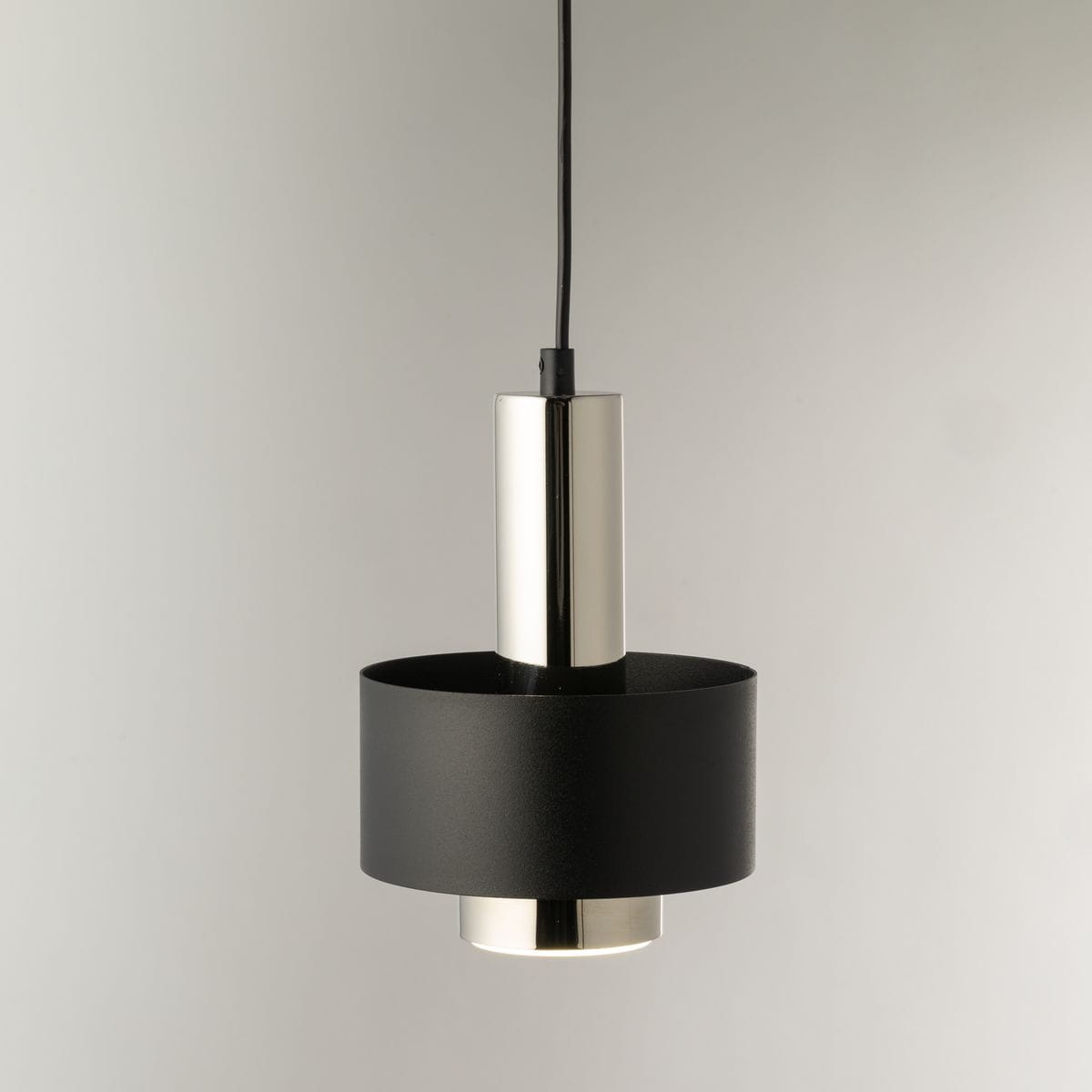 Lampa wisząca Rif Lux D15 w kolorze czarnym i srebrnym, z metalową rurką oraz okrągłym kloszem. Zawieszona na czarnym przewodzie, w frontalnym ujęciu. Wysokiej jakości materiały i nowoczesny design, idealna do wnętrz.