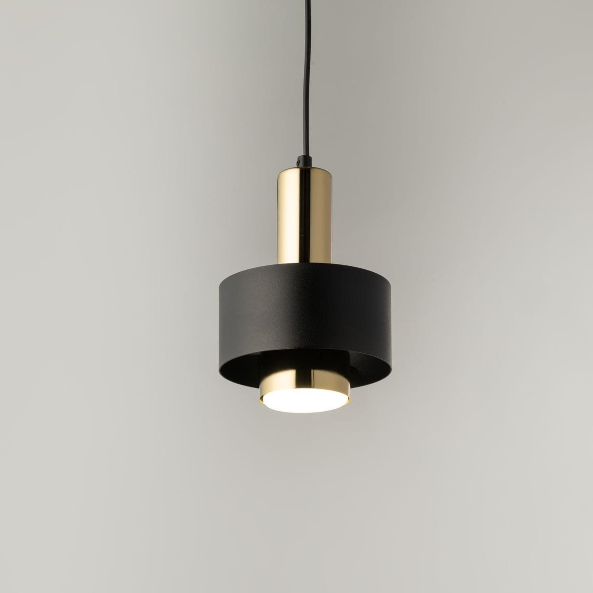 Lampa wisząca Rif Lux D15 w kolorze czarnym i złotym, z okrągłym kloszem oraz metalowym wykończeniem. Ujęcie z góry, zawieszona na cienkim przewodzie, z widoczną oprawą GX53. Tło jasne, minimalistyczne, podkreślające elegancki design.