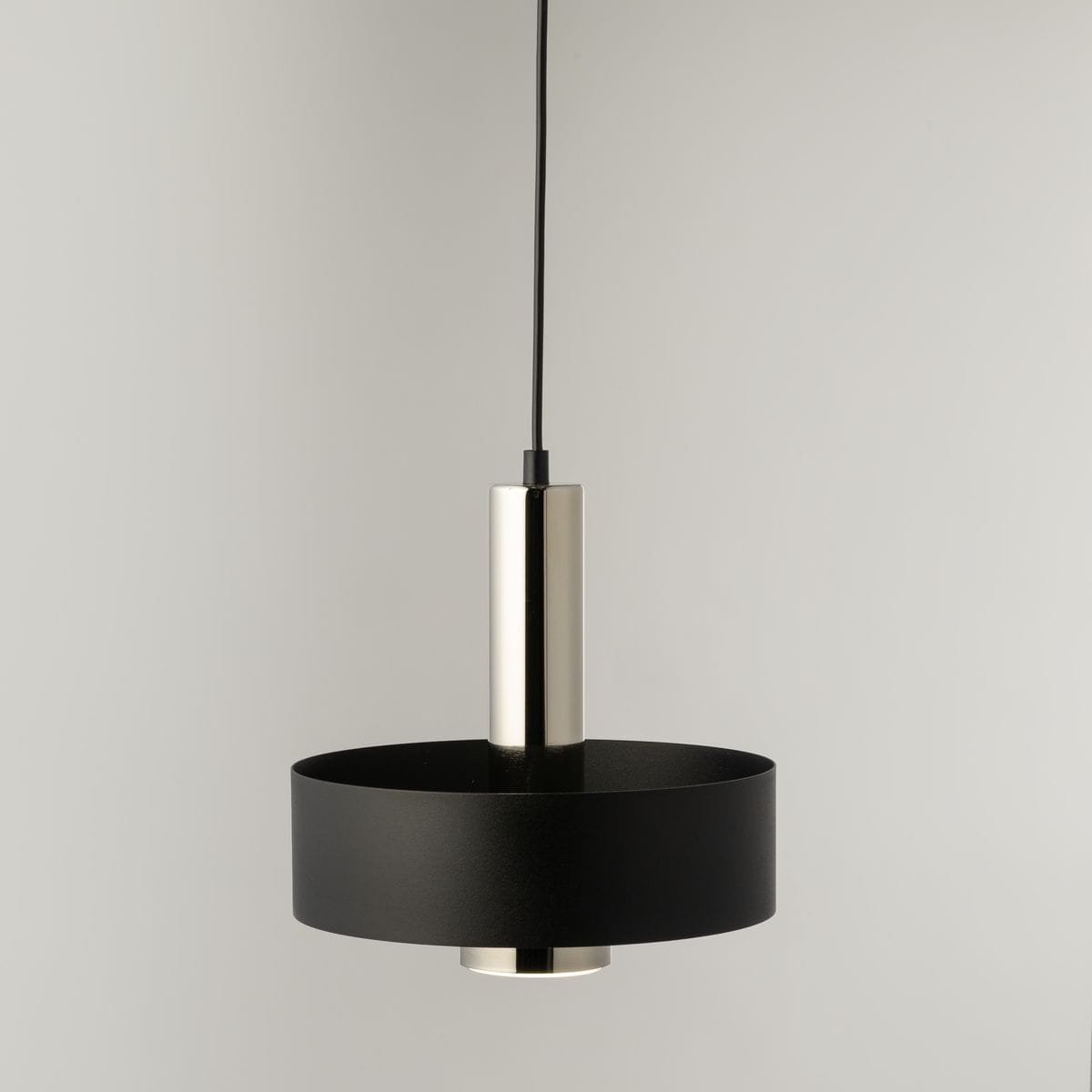 Lampa wisząca Rif Lux D25 w kolorze czarnym i srebrnym, z okrągłym, matowym kloszem i błyszczącym metalowym elementem. Zawieszona na cienkim, czarnym przewodzie, z gniazdem na żarówkę GX53. Ujęcie frontalne.