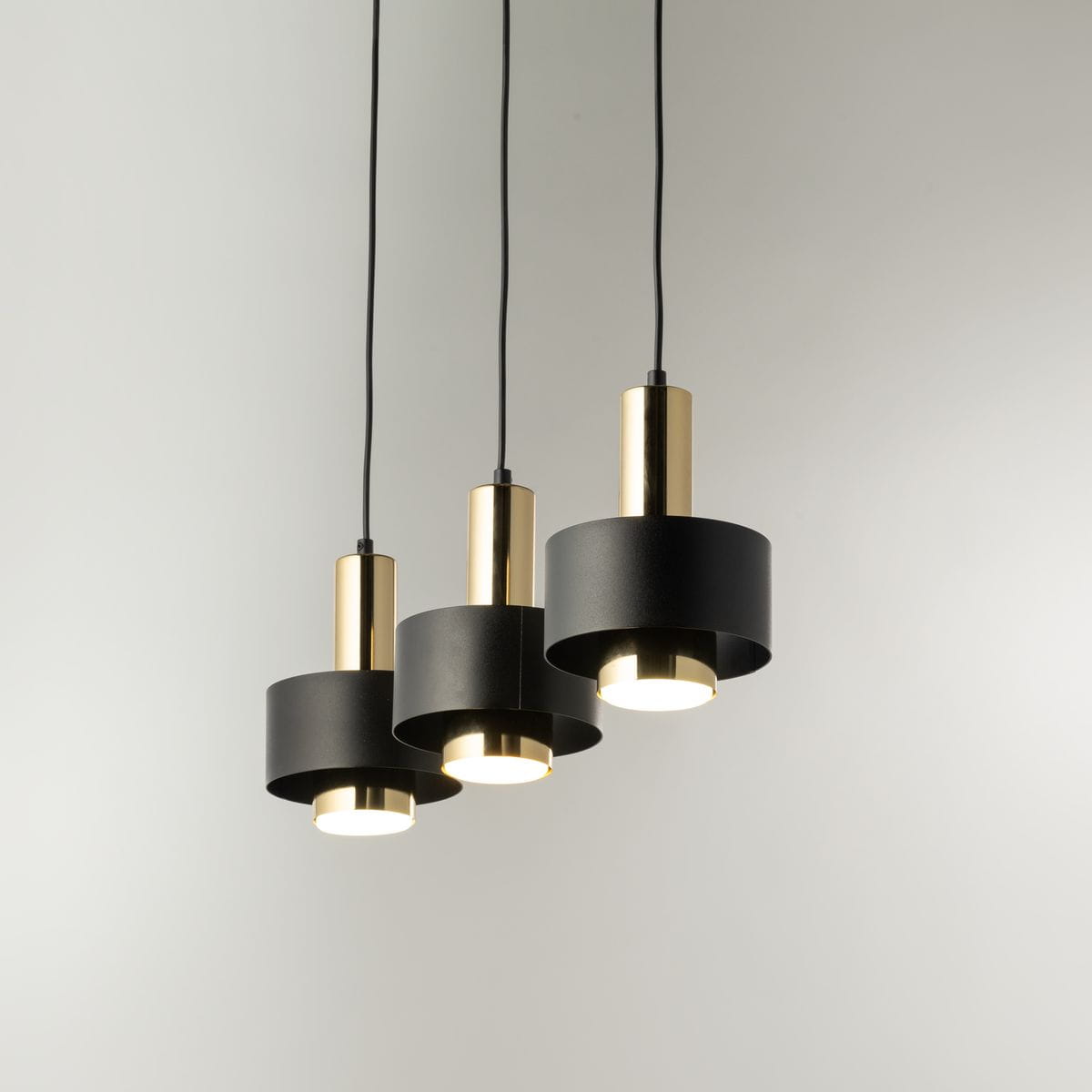 Lampa wisząca Rif Lux 3xGX53 w kolorze czarnym z złotymi akcentami. Trzy cylindryczne klosze o matowej powierzchni, zawieszone na czarnych przewodach. Przeznaczona do nowoczesnych wnętrz, idealna do oświetlenia przestrzeni.