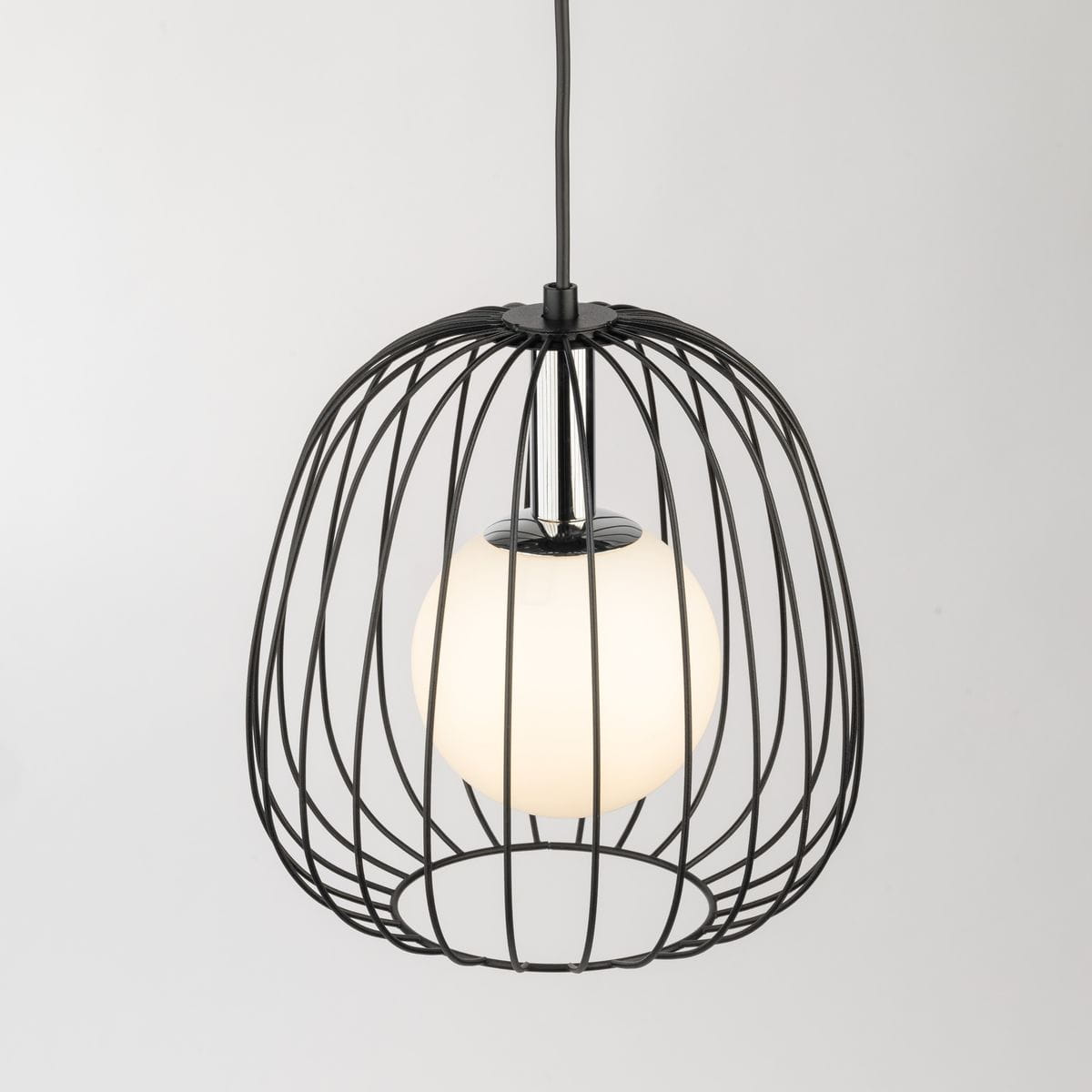 Lampa wisząca Bell D24 w kolorze czarnym i srebrnym, z metalową klatką oraz białym, okrągłym kloszem. Ujęcie z góry, produkt zawieszony. Widoczny detal mocowania i źródła światła G9. Tło jasne, proste.