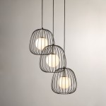 Lampa wisząca Bell z trzema kloszami w formie metalowych siatek w kolorze czarnym, z białymi okrągłymi żarówkami. Produkt zawieszony na cienkich linkach, w minimalistycznym stylu, na jasnym tle.