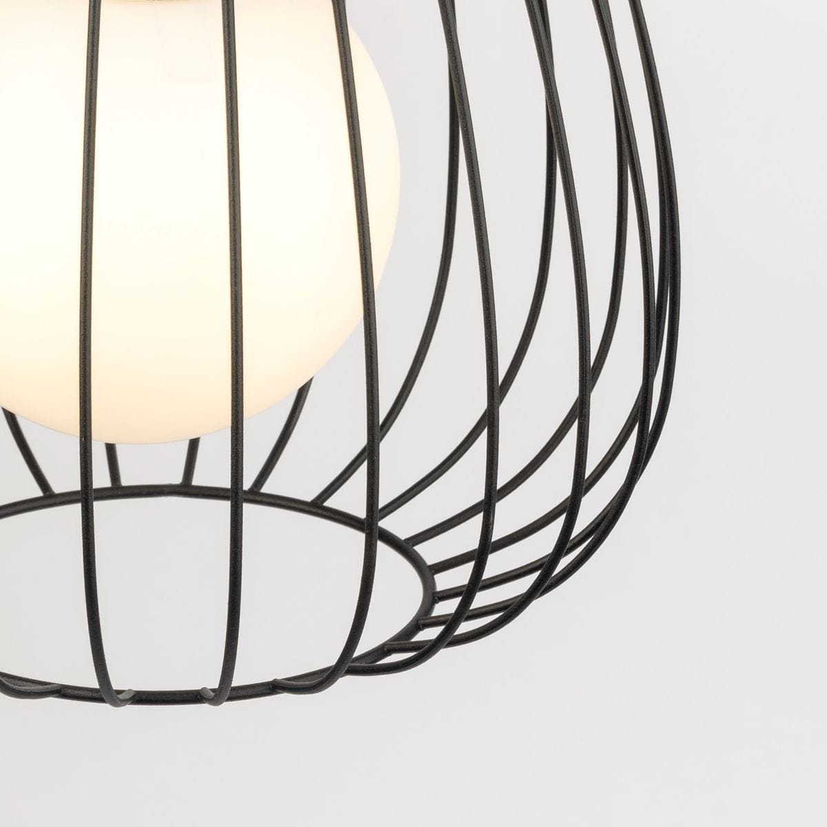 Lampa wisząca Bell D24 w kolorze czarnym z metalową siatką i okrągłym kloszem z białego szkła. Ujęcie w zbliżeniu na detal konstrukcji, z wyeksponowanym kształtem klosza oraz otwartą podstawą. Tło jednolite, jasne.