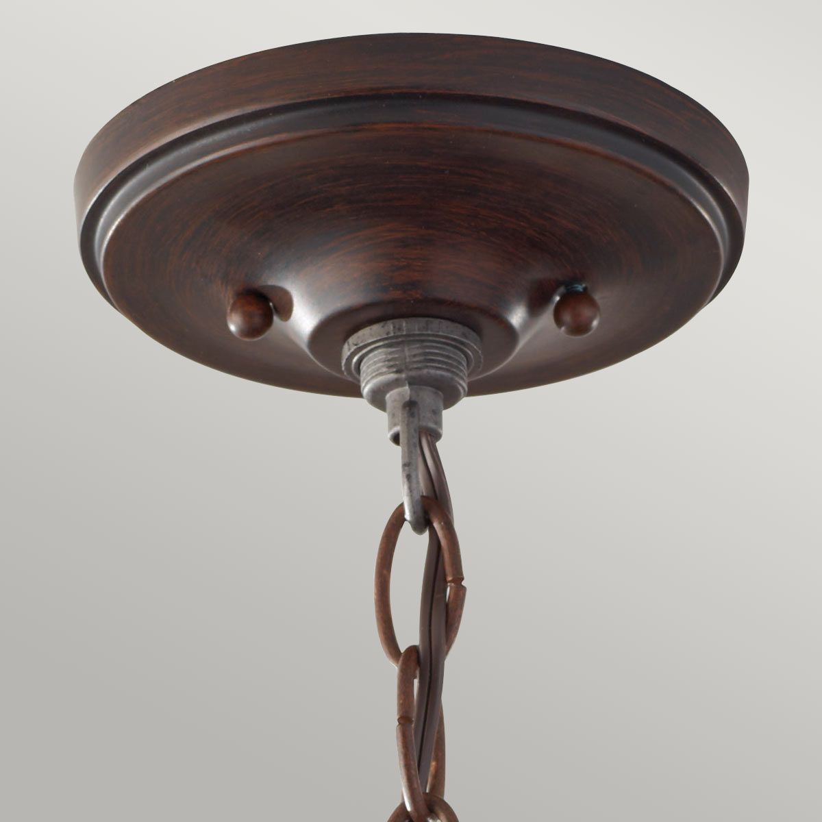 Lampa sufitowa Pickering w kolorze starym brązie, z mocowaniem na trzy źródła światła E14. Widoczna dekoracyjna podsufitka z okrągłym kształtem oraz metalowy element z łańcuszkiem. Kąt ujęcia: z dołu, ukazujący detale mocowania.