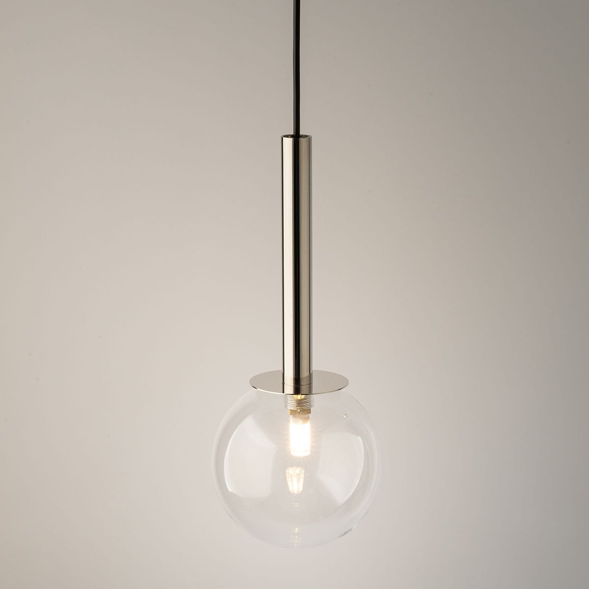 Lampa wisząca Daisy z jedną oprawą G9, srebrna metalowa konstrukcja z transparentną szklaną kulą. Produkt zawieszony na czarnym przewodzie, widoczny z przodu, podkreślający minimalistyczny design.