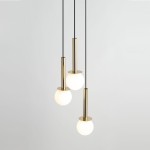 Lampa wisząca Daisy 3xG9 w złotym i białym kolorze, składająca się z trzech okrągłych kloszy z mlecznego szkła zawieszonych na cienkich czarnych linkach. Klosze umieszczone na cylindrycznych podstawach z połyskującego metalu.