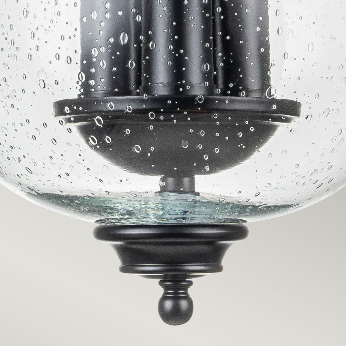 Lampa sufitowa Pickering z trzema gniazdami E14, czarna, z przejrzystym kloszem ze szkła z bąbelkami powietrza. Klosz osadzony na czarnej podstawie z dekoracyjnym wykończeniem. Ujęcie od dołu, pokazujące detale konstrukcji.
