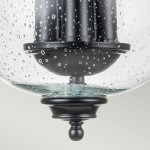 Lampa sufitowa Pickering z trzema gniazdami E14, czarna, z przejrzystym kloszem ze szkła z bąbelkami powietrza. Klosz osadzony na czarnej podstawie z dekoracyjnym wykończeniem. Ujęcie od dołu, pokazujące detale konstrukcji.