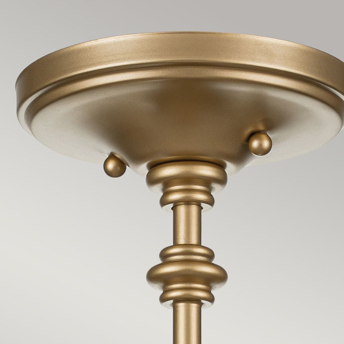 Lampa sufitowa Pickering z mosiądzu, z trzema gniazdami E14. Posiada okrągłą podstawę z ozdobnymi detalami, w tym kulistymi elementami oraz gładką, metaliczną powierzchnię w kolorze złotym. Ujęcie z dołu, pokazujące szczegóły konstrukcji.