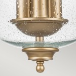 Lampa sufitowa Pickering 3xE14 w mosiężnym wykończeniu z przezroczystym kloszem z fakturą wody. Widoczny jest okrągły element mocujący z dekoracyjną kulką na dole. Klosz o zaokrąglonym kształcie.