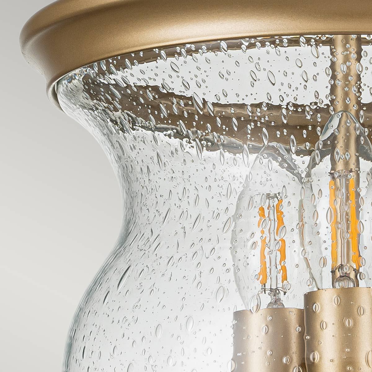Lampa sufitowa Pickering z mosiądzu, z trzema gniazdami E14. Szklany klosz z fakturą kropli wody, odsłaniający żarówki z widocznymi żarnikiem. Górna część w kolorze mosiądzu, elegancka forma, montowana na suficie.