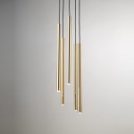 Lampa wisząca Sopel Lux z pięcioma złotymi rurkami G9. Rurki o różnych długościach zawieszone na czarnych przewodach, w minimalistycznym stylu. Tło jasne, jednolite, podkreślające elegancję lampy.