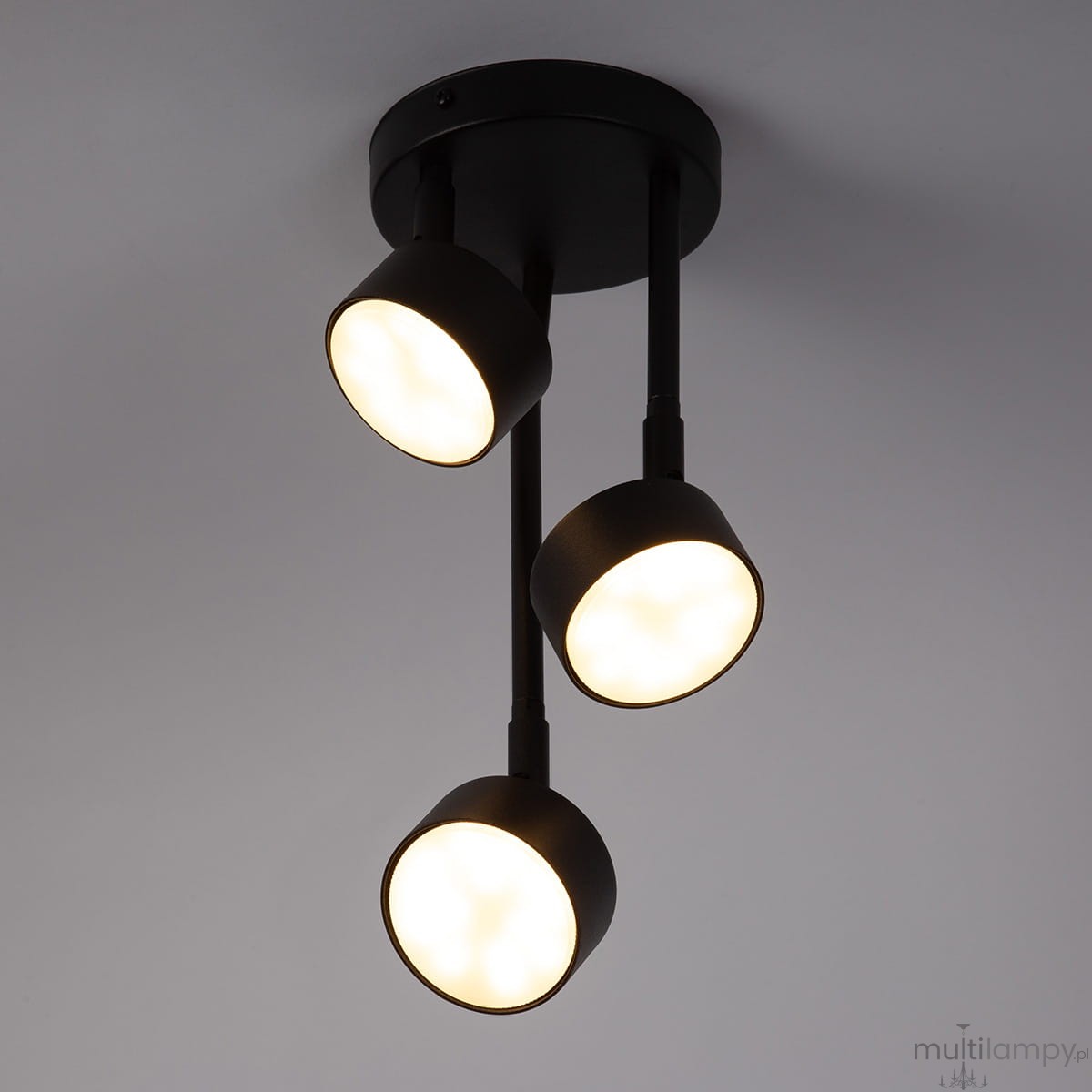 Lampa wisząca Nemo 3xGX53 w kolorze czarnym, składająca się z trzech okrągłych kloszy na długich ramionach. Ujęcie z dołu, pokazujące cały produkt zamontowany na suficie. Klosze emitują ciepłe światło.