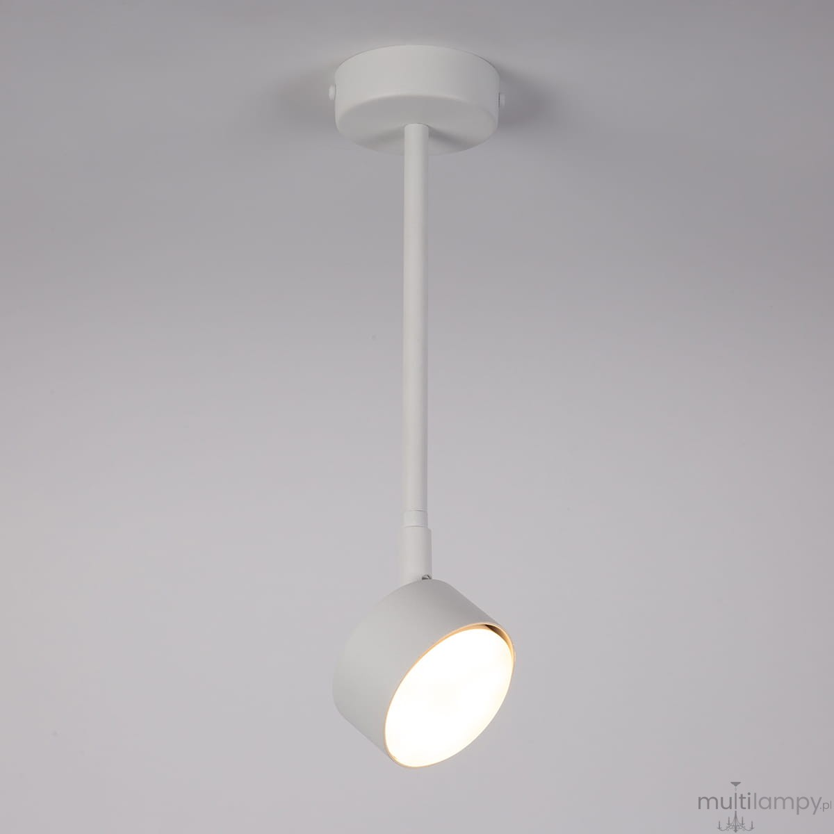 Lampa wisząca Nemo H35 w białym kolorze z oprawą na jedną żarówkę GX53. Produkt zawieszony na prostym, białym stelażu, z okrągłym kloszem emitującym światło. Tło szare, minimalistyczne.