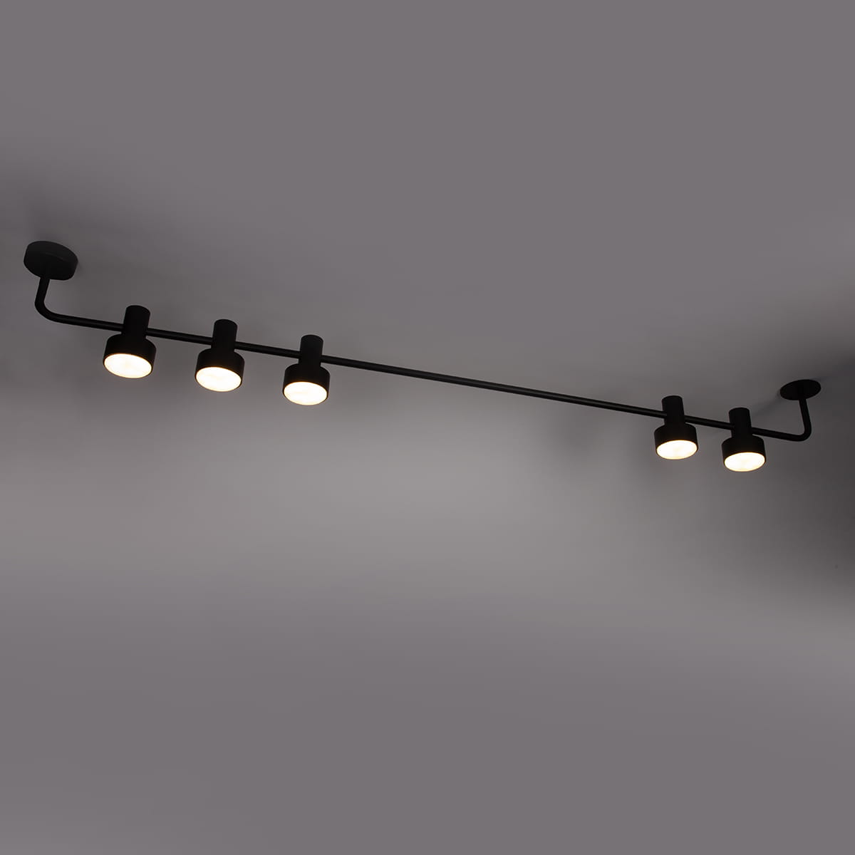 Czarna lampa sufitowa Mona z pięcioma punktami świetlnymi GX53. Ułożona poziomo, z metalową konstrukcją i okrągłymi kloszami, zamontowana na suficie. Prosta, nowoczesna forma, idealna do oświetlenia wnętrz.