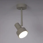 Lampa wisząca Mona H25 w kolorze szaro-beżowym, z metalowym kloszem w formie stożka. Zawieszona na prostym uchwycie, skierowana w dół. Przeznaczona do źródła światła GX53. Tło w jasnym kolorze, co podkreśla jej nowoczesny design.