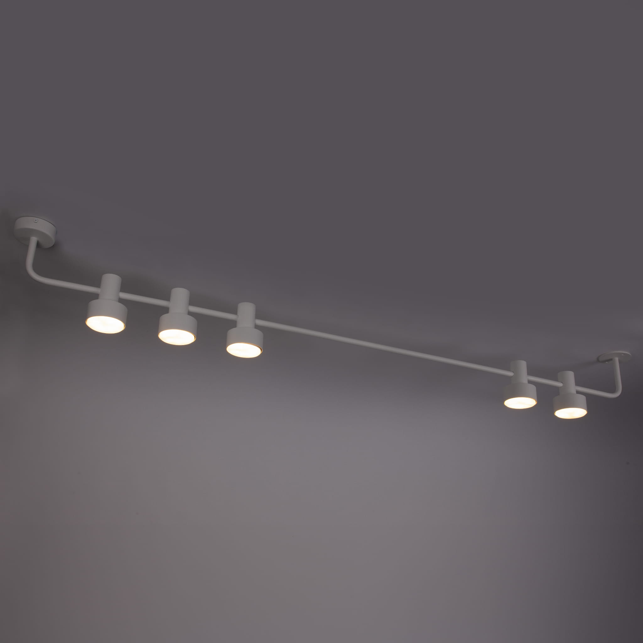 Lampa sufitowa Mona w białym kolorze z pięcioma oprawami GX53. Ułożona poziomo, z zamontowanym mocowaniem do sufitu. Prosty, nowoczesny design, idealna do oświetlenia wnętrz. Światło skierowane w dół, efektowna w aranżacji.