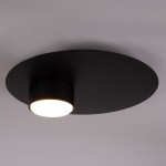 Czarna lampa sufitowa Star z jedną oprawą na żarówkę GX53. Okrągła, matowa podstawa z zamontowanym cylindrycznym kloszem, emitującym ciepłe światło. Ujęcie z góry, ukazujące minimalistyczny design.