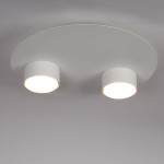 Biała lampa sufitowa Star z dwoma źródłami światła GX53. Okrągła, matowa podstawa z dwoma cylindrycznymi kloszami, emitującymi jasne światło. Ujęcie z góry, ukazujące całość konstrukcji.
