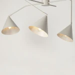 Lampa sufitowa Galaxy z trzema kloszami w kształcie stożka w kolorze szarym, z mocowaniem na żarówki E27. Klosze skierowane są w różne strony, a wnętrze kloszy ma złotą barwę, co dodaje elegancji. Produkt zamontowany w pozycji wiszącej.