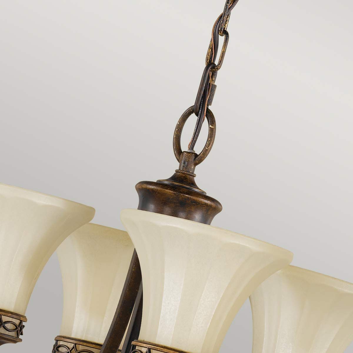 Lampa wisząca Drawing Room z czterema kloszami E27 w postarzanym brązie. Klosze w kształcie tulipanów z matowego szkła, mocowanie z ozdobnym łańcuchem. Produkt zawieszony, z eleganckim wykończeniem i detalami, na jasnym tle.