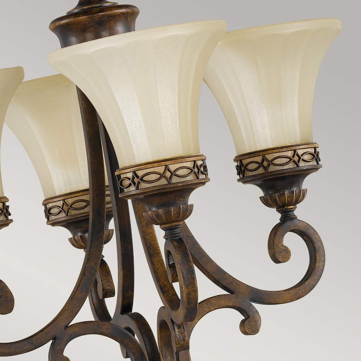 Lampa wisząca Drawing Room z czterema kloszami E27, w postarzanym brązie. Klosze mają kształt kielicha z delikatnym żłobieniem, a metalowe mocowanie z dekoracyjnym wzorem. Produkt zawieszony w centralnej pozycji.