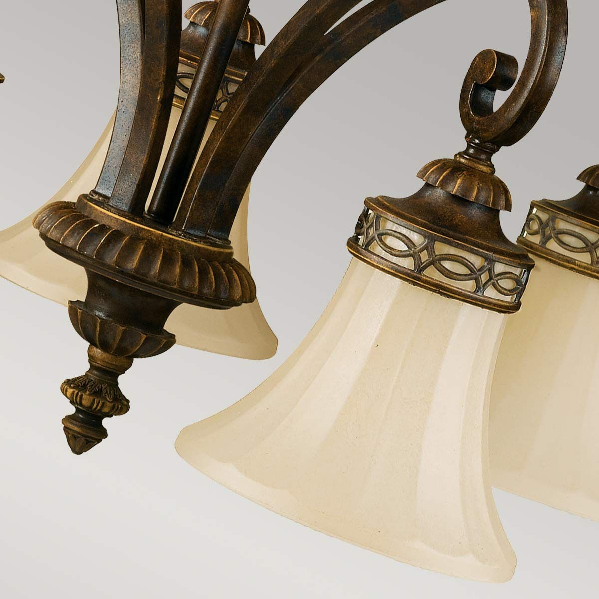 Lampa wisząca Drawing Room, postarzany brąz, z pięcioma kloszami w kształcie dzwonu z matowego szkła. Uchwyt ozdobiony detalami w złotym kolorze, styl vintage. Klosze zamocowane na eleganckich ramionach, z widocznymi dekoracyjnymi elementami.