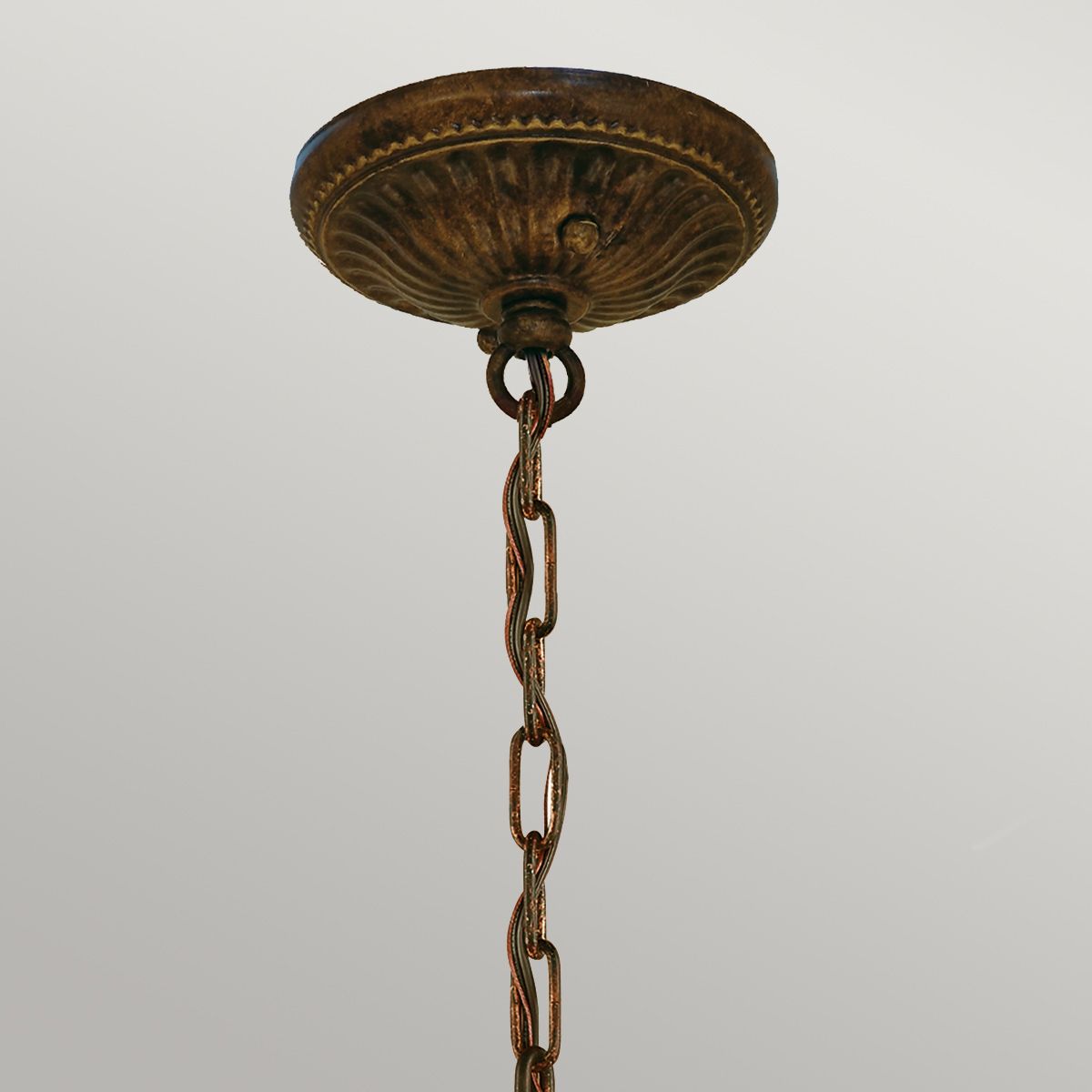 Lampa wisząca Drawing Room w postarzanym brązie z pięcioma miejscami na żarówki E27. Ujęcie z dołu, pokazujące ozdobny uchwyt i łańcuch. Widać detale tekstury i wykończenia.