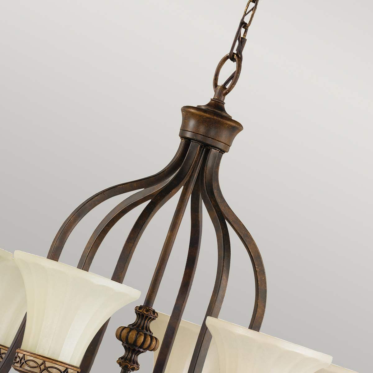 Lampa wisząca Drawing Room z postarzanym brązem, z sześcioma kloszami w kształcie tulipana z matowego szkła. Ujęcie z góry, pokazujące detale mocowania i dekoracyjne elementy. Wisi na łańcuchu, idealna do wnętrz klasycznych.