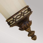 Kinkiet Drawing Room U w postarzanym brązie z kloszem z mlecznego szkła, ozdobiony metalową obręczą w geometryczny wzór. Ujęcie z boku, ukazujące detale mocowania i dekoracyjny element na końcu.