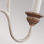 Lampa wisząca Hartsville w kolorze kredowej bieli z drewnianymi detalami. Widoczny fragment uchwytu z eleganckim wykończeniem, zakrzywione ramiona oraz klasyczne zdobienia. Idealna do aranżacji wnętrz.