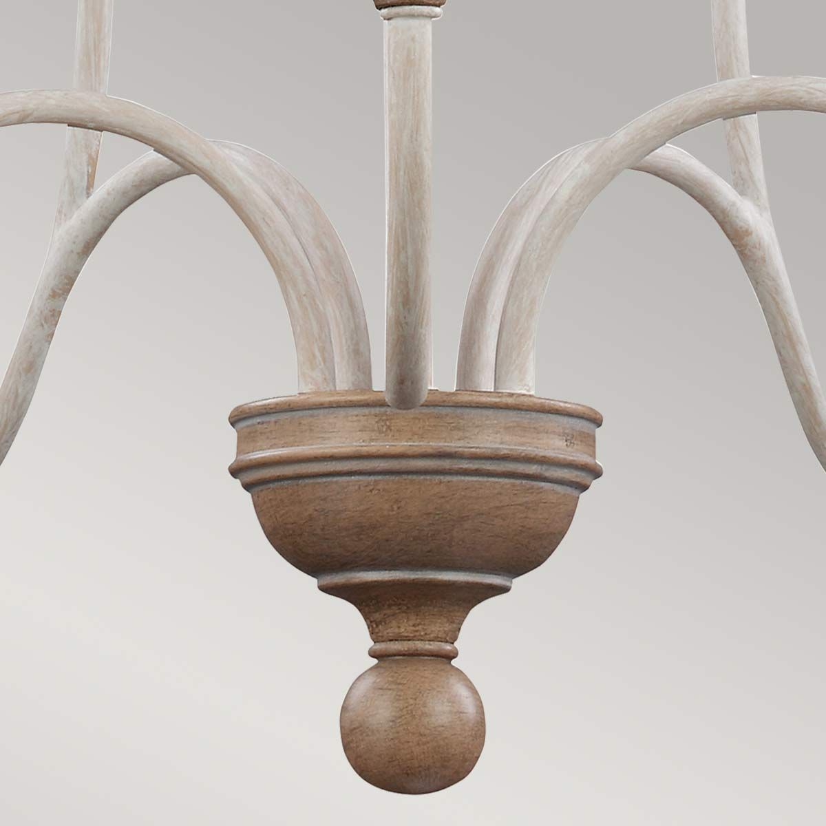 Lampa wisząca Hartsville w kredowej bieli z pięcioma ramionami na żarówki E14. U podstawy znajduje się dekoracyjny, okrągły element w kolorze naturalnego drewna, z subtelnymi zdobieniami. Ramiona mają delikatnie teksturowaną powierzchnię.