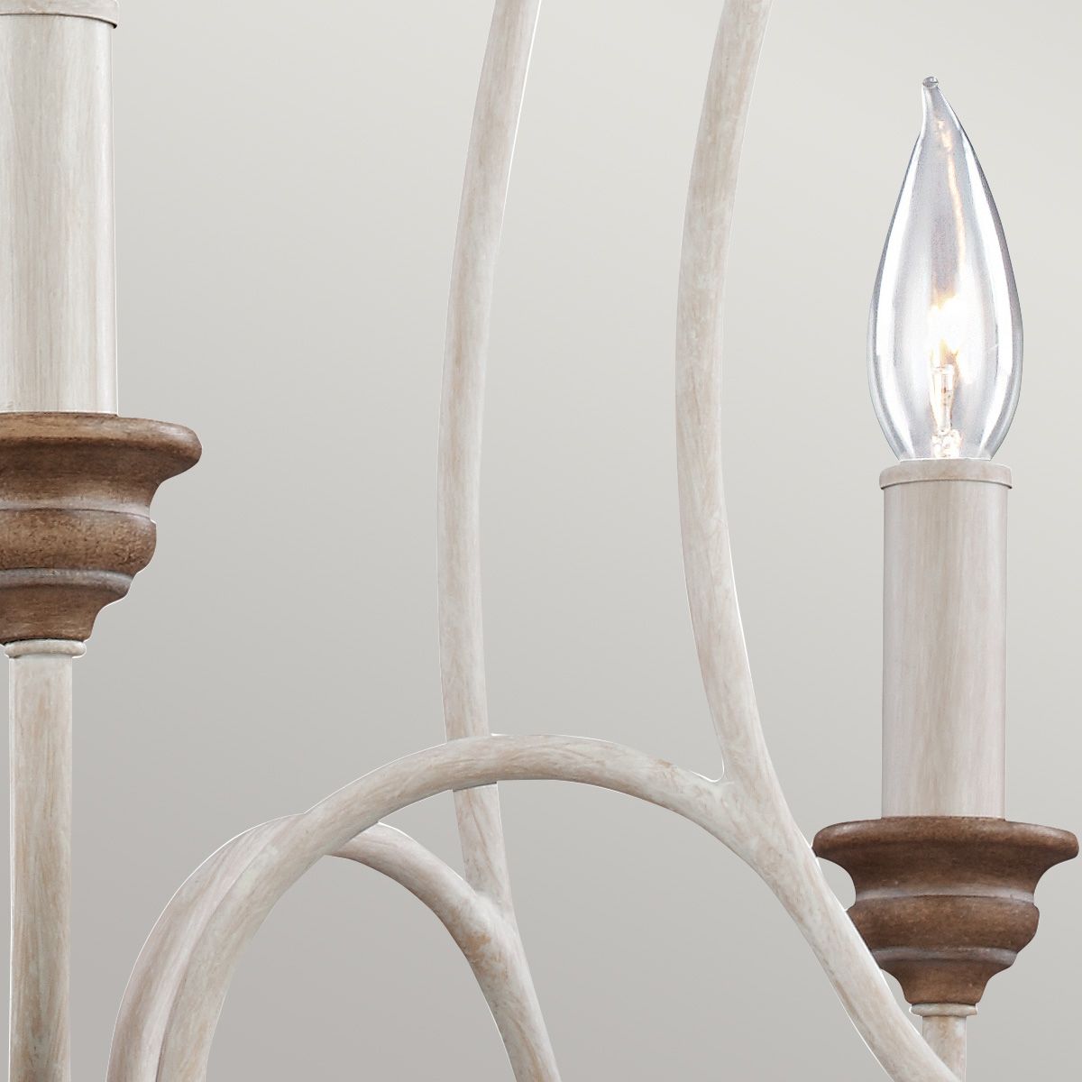 Lampa wisząca Hartsville w kolorze kredowej bieli, z pięcioma miejscami na żarówki E14. Widoczne drewniane detale w ciepłym odcieniu oraz eleganckie, zakrzywione ramiona. Kąt ujęcia zbliżony na elementy konstrukcyjne.