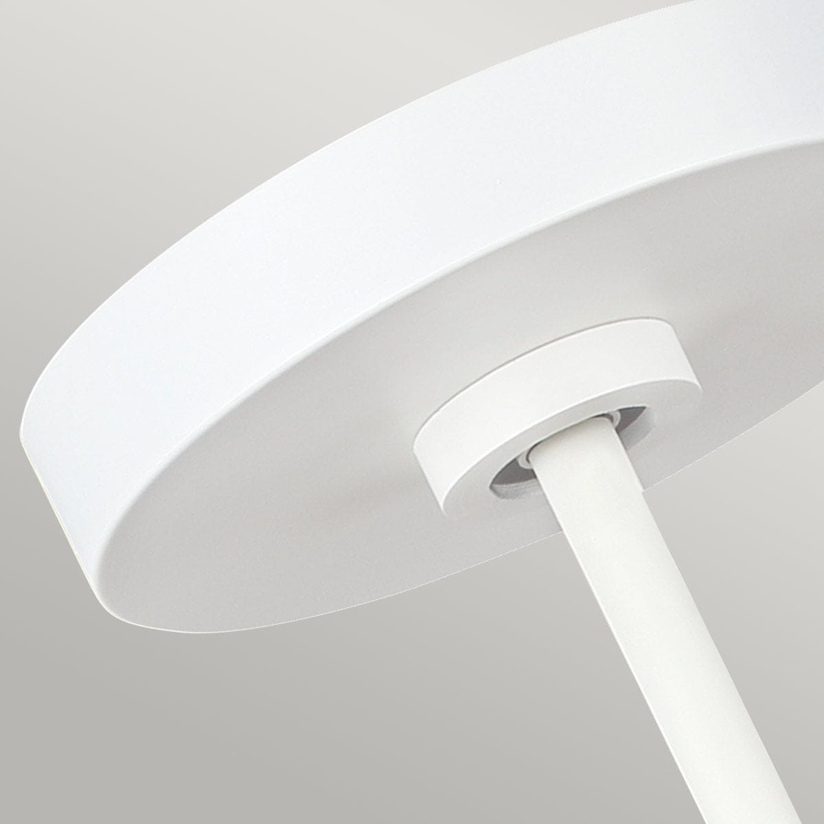 Lampa wisząca Brisbin z białym, okrągłym kloszem i prostym, białym mocowaniem. Ujęcie z dołu, ukazujące szczegóły konstrukcji i estetykę. Wykonana z metalu, idealna do nowoczesnych wnętrz.